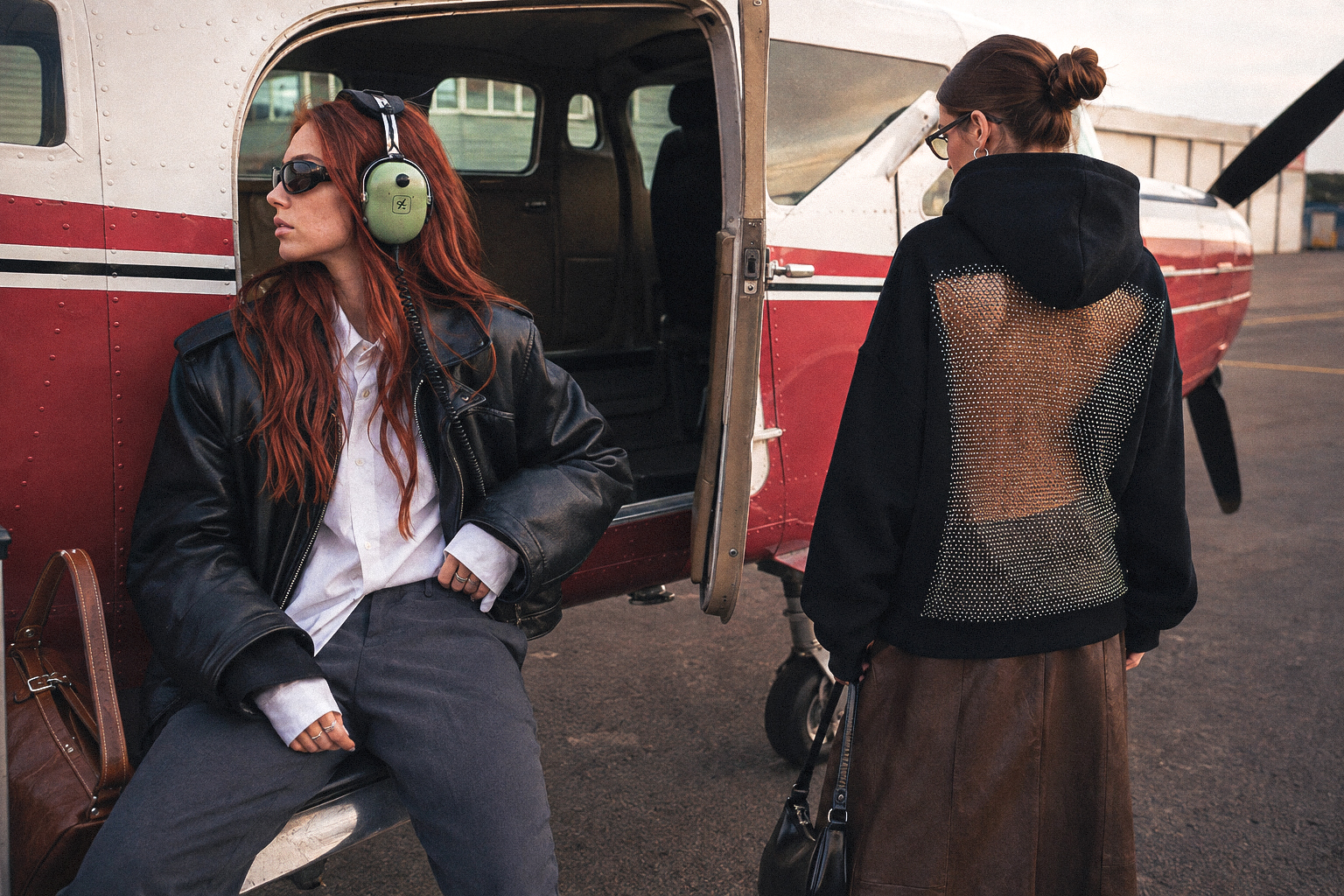 HONEY RAGE hoodie, styled beside a vintage aircraft